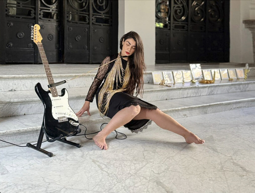 Monica Mura realizando la acción sonora con una guitarra fender en el Lázaro Galdiano, en 2014